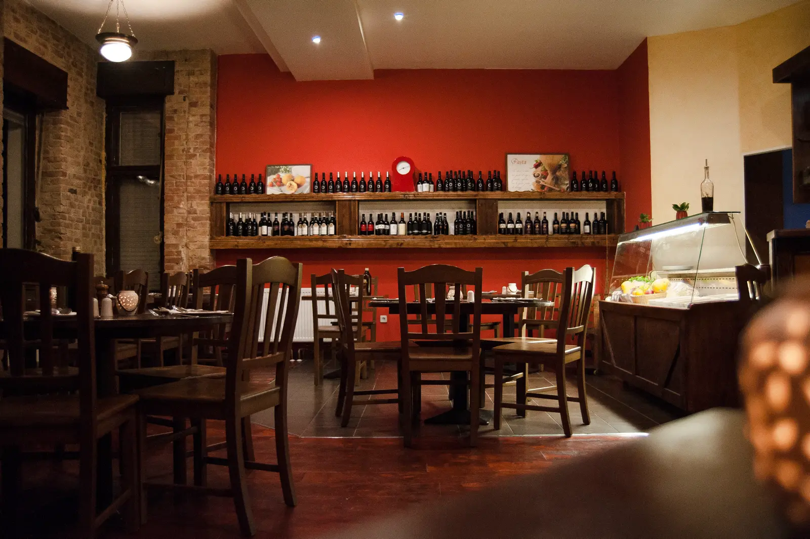 Trattoria Lauretta Berlin — Tischdekoration mit Menükarte und Weinregal